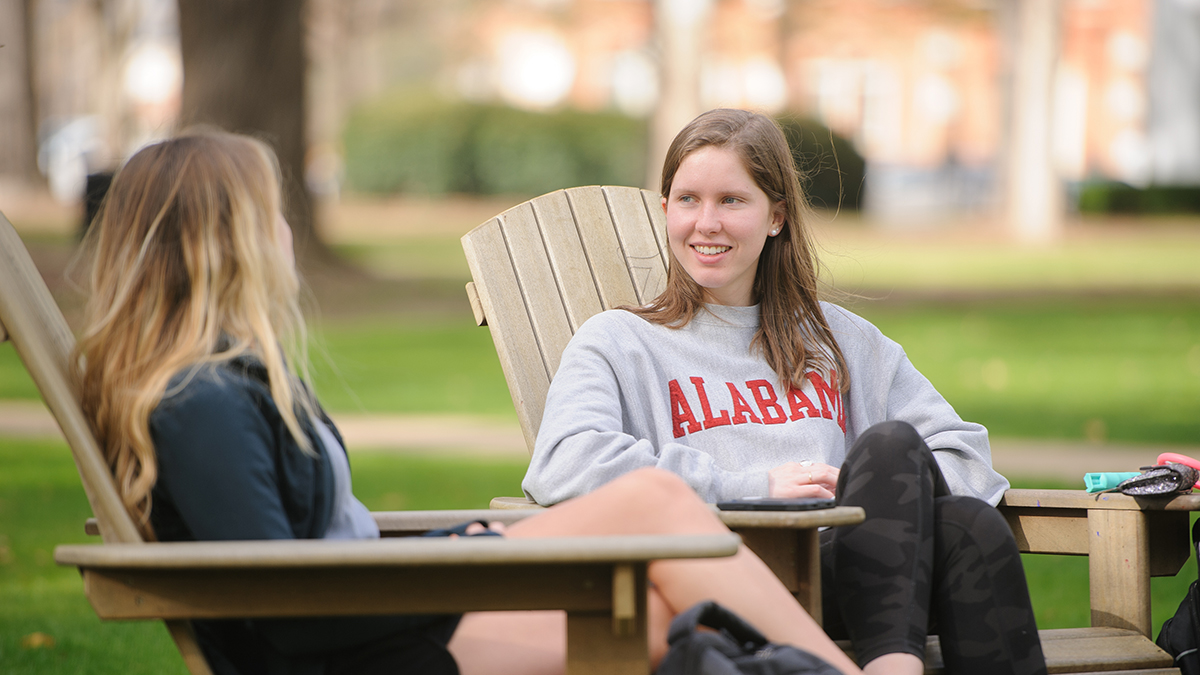 two female students on Adirondack chairs